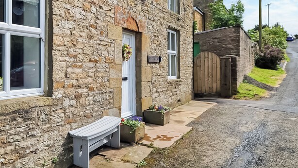 A stone building with a white door, a bench outside, and a sign reading "Westview."
