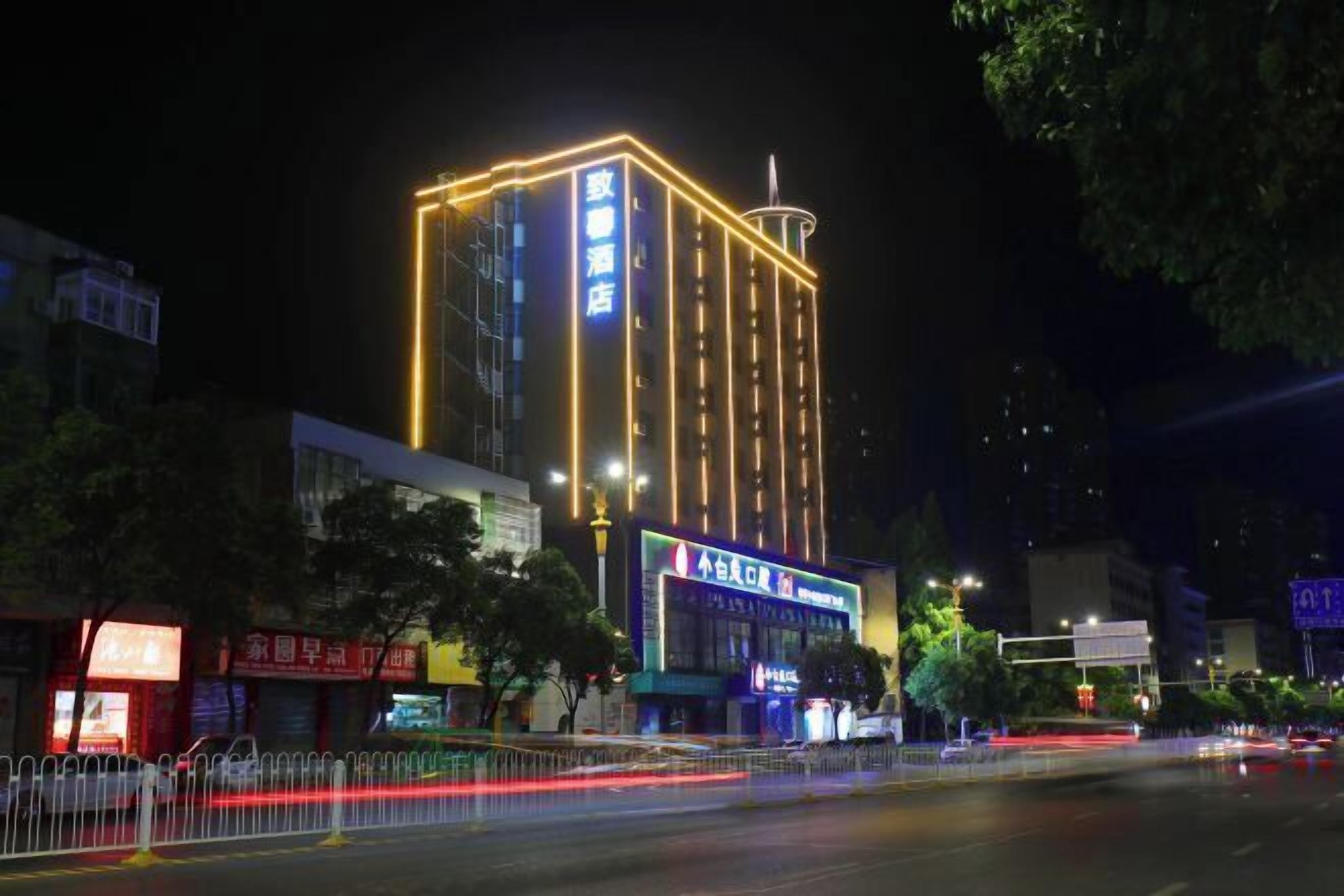 A tall hotel with illuminated signage and a modern design.