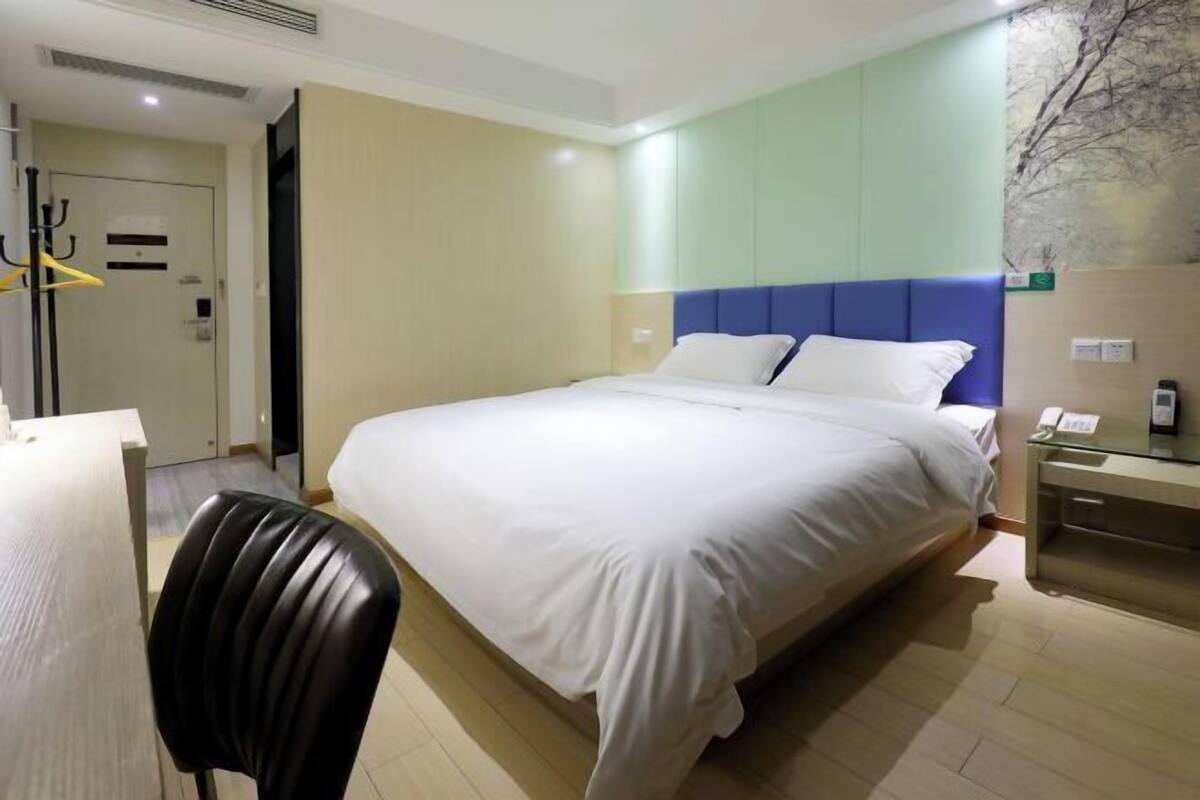 Una habitación de hotel con una cama, un escritorio y una silla.