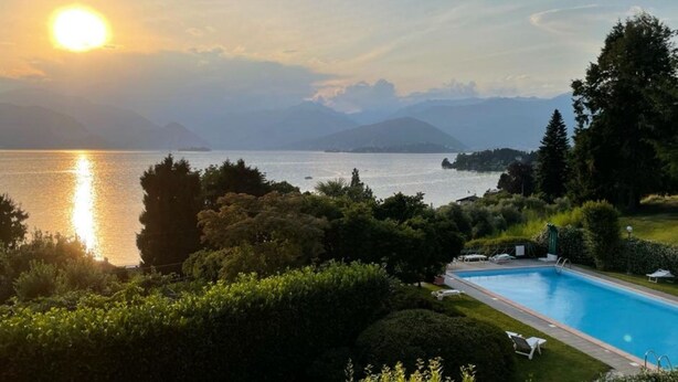 A swimming pool with a view of a lake and mountains in the background. - The House on the Lake (Reno)