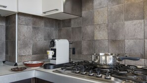A modern kitchen with a gas stove, a coffee maker, and a bowl on the counter. - The House on the Lake (Reno)