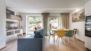 Un salon moderne comprenant un canapé, une table à manger, des chaises et un téléviseur.
