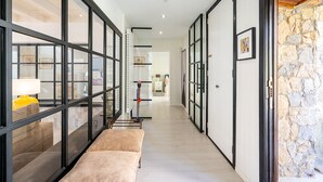 Un couloir avec des portes vitrées, un banc et un scooter.