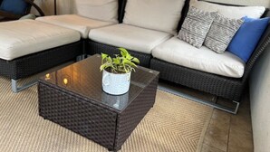 En modulsofa med et glasbord og en potteplante.
