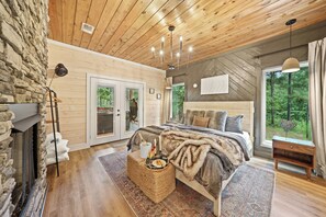 Relax in a warm and inviting space with a large bed, fireplace, and cozy seating area.