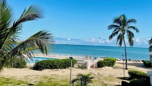 A beach view with a pool area, palm trees, and a clear blue sky. - Côté Mer - NBBC - 2 bedrooms beachfront (Marigot)