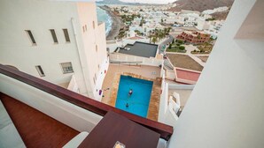 A pool area with a view of a coastal town and mountains in the background. - Cozy Apartment by the Sea in Carboneras (Carboneras)