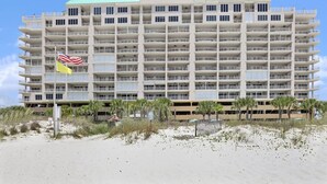 Un hotel de varios pisos con balcones, situado cerca de una playa.