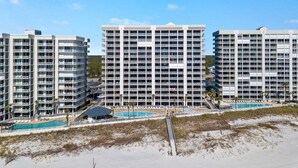 Ein Hochhotel mit mehreren Balkonen, einem Poolbereich und Blick auf den Strand.