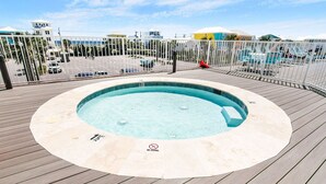 A hot tub on a wooden deck with a pool in the background. - Sanibel 306- Beach Access Gulf Views Sun Deck (Gulf Shores)