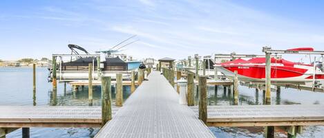 A pier leading to docked boats, with a clear sky above.
