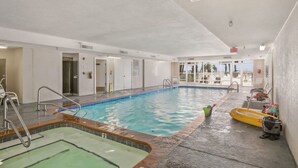 An indoor swimming pool with a clear view of the pool area, a lifeguard chair, and a pool ladder. - Regency Isle 711 2 BR 2 5 BA Sleep 8 Gulf-front (Orange Beach)