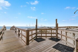 A wooden boardwalk leading to a sandy beach with a clear sky. - Lei Lani 218 Best of Beach Bay (Orange Beach)