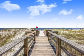 A wooden boardwalk leading to a beach with a red flag indicating no swimming. - Palm Beach 22D 2 BR 2 5 BA Beach-view (Orange Beach)