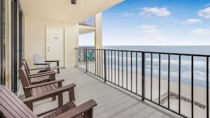 A balcony with wooden chairs, a door, and a view of the beach. - Phoenix II 2101-amenities Galore Beachfront (Orange Beach)