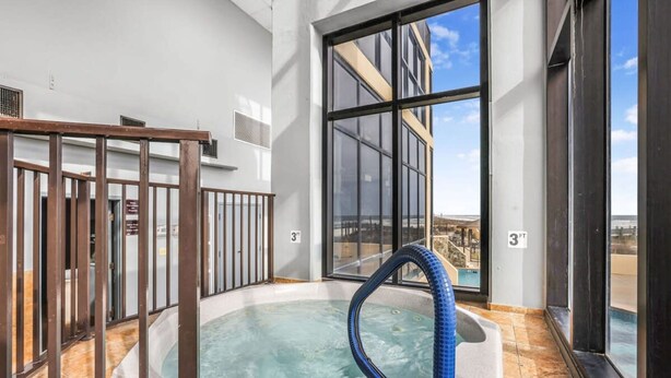 A hot tub with a blue hose, a view of a building, and a 3 FT height sign. - Phoenix II 2101-amenities Galore Beachfront (Orange Beach)