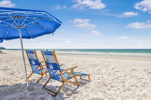 A beach with a blue umbrella and two wooden beach chairs. - Gulf Village 214- Close to the Hangout Beachfront (Gulf Shores)