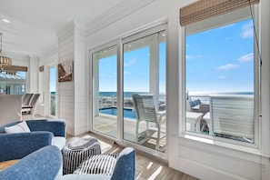 A spacious room with a large sliding glass door leading to a balcony with a pool view. - Lil Tip Sea 8 BR Private Pool Elevator Beach (Gulf Shores)