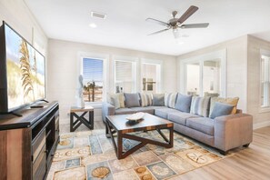 Relax in this spacious living room with a large sofa, coffee table, and flat-screen TV.