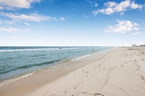 A beach with a clear sky and calm sea. - Life s Porpoise A Steps From Beach Pool (Gulf Shores)