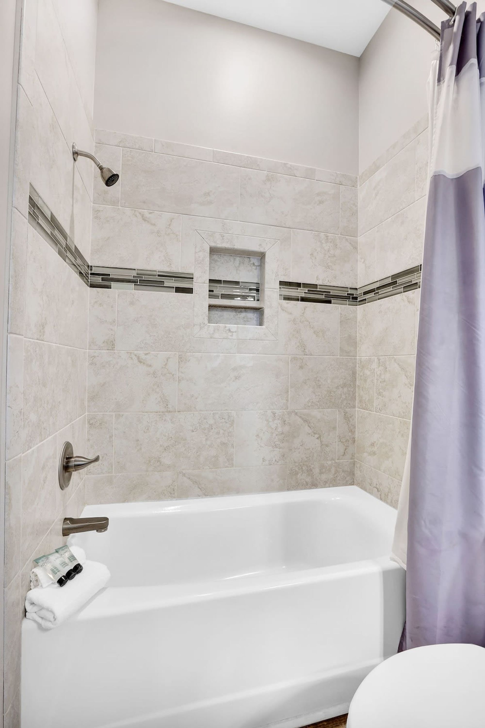 Une salle de bain moderne avec une baignoire sur pieds, une douche et un porte-serviettes.