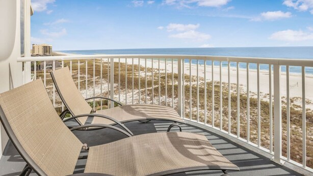 A balcony with two lounge chairs facing a beach. - Spanish Key 504 Next to Flora-bama Sleeps 9 (Pensacola)