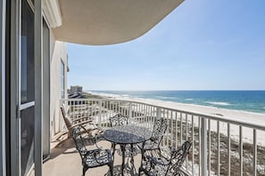 A balcony with a table and chairs overlooking a beach. - Spanish Key 505 3 3 Next to the Flora-bama (Pensacola)