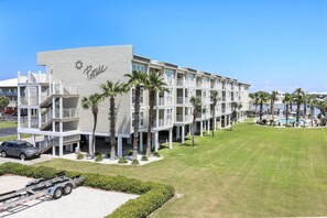 A multi-story hotel with a pool area, palm trees, and a clear blue sky. - Portside 204 Best of Beach Bay (Pensacola)