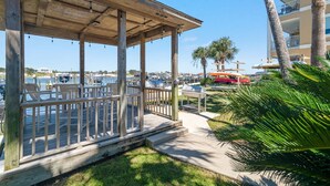 A wooden deck with chairs and a view of the marina. - Portside 204 Best of Beach Bay (Pensacola)
