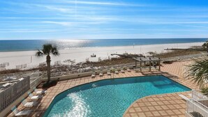 A pool area with a view of the beach and ocean.