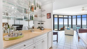 Eine moderne Küche mit einem Weinkühlschrank aus Glas, einer Kaffeemaschine und Blick auf den Balkon.