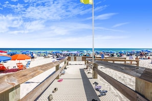 A wooden boardwalk leading to a beach with umbrellas and beach chairs. - Phoenix West 2508 Views Galore 3 4 Lazy River (Orange Beach)