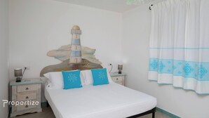 A bedroom with a bed, nightstands, a lamp, a wall mural, and a curtain. - Villa Azzurra by Propertize - a few steps from the sea (Pittulongu)