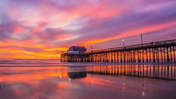 A pier extending into calm waters with a sunset in the background. - The Chic Beach Studio w/spacious patio

 (Newport Beach)