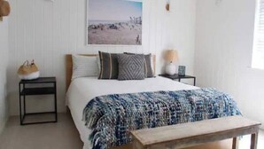A bedroom with a bed, a bedside table, a lamp, and a picture on the wall. - The Chic Beach Studio w/spacious patio

 (Newport Beach)