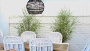 A patio area with wicker furniture, a table, and chairs. - The Chic Beach Studio w/spacious patio

 (Newport Beach)