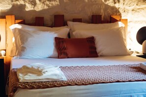 A bed with white linens, a red pillow, and a folded towel on a textured bedspread. - a charming two-bedroom accommodation unit of 39 m² (Sortelha)