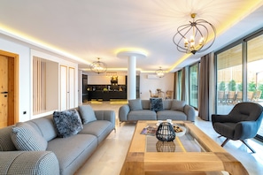 A modern living room with a sofa set, a coffee table, and a dining area.