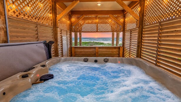 Un bain à remous avec vue sur l’océan, entouré de murs en treillis de bois.