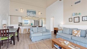 Ein großzügiger Wohnbereich mit Esstisch, zwei Sofas und Deckenventilator.