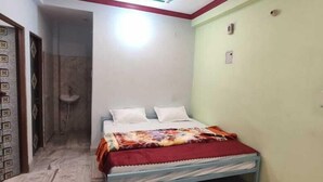 A bedroom with a bed, a ceiling fan, and a light fixture.