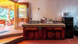 A kitchen with a wooden island, a microwave, and a refrigerator. - Cabañas Elsa María (Atlautla)