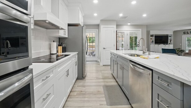 A modern kitchen with white cabinetry, stainless steel appliances, and a marble countertop. - House with Hot tub, close to Marina, in a Golf Course Community (Hertford)