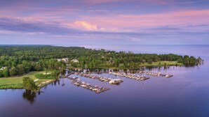 An aerial view of a marina with boats docked, surrounded by greenery and houses. - House with Hot tub, close to Marina, in a Golf Course Community (Hertford)