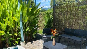 An outdoor patio with a pool, a table with a vase, and a sofa. - Morning Glory (Bahía Ballena)