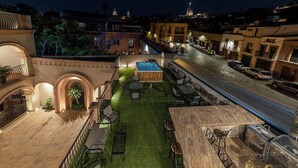 A rooftop terrace with a pool, outdoor seating, and a view of the cityscape at night. - Hotel Suites Cristal Casa Vacacional (San Miguel de Allende)