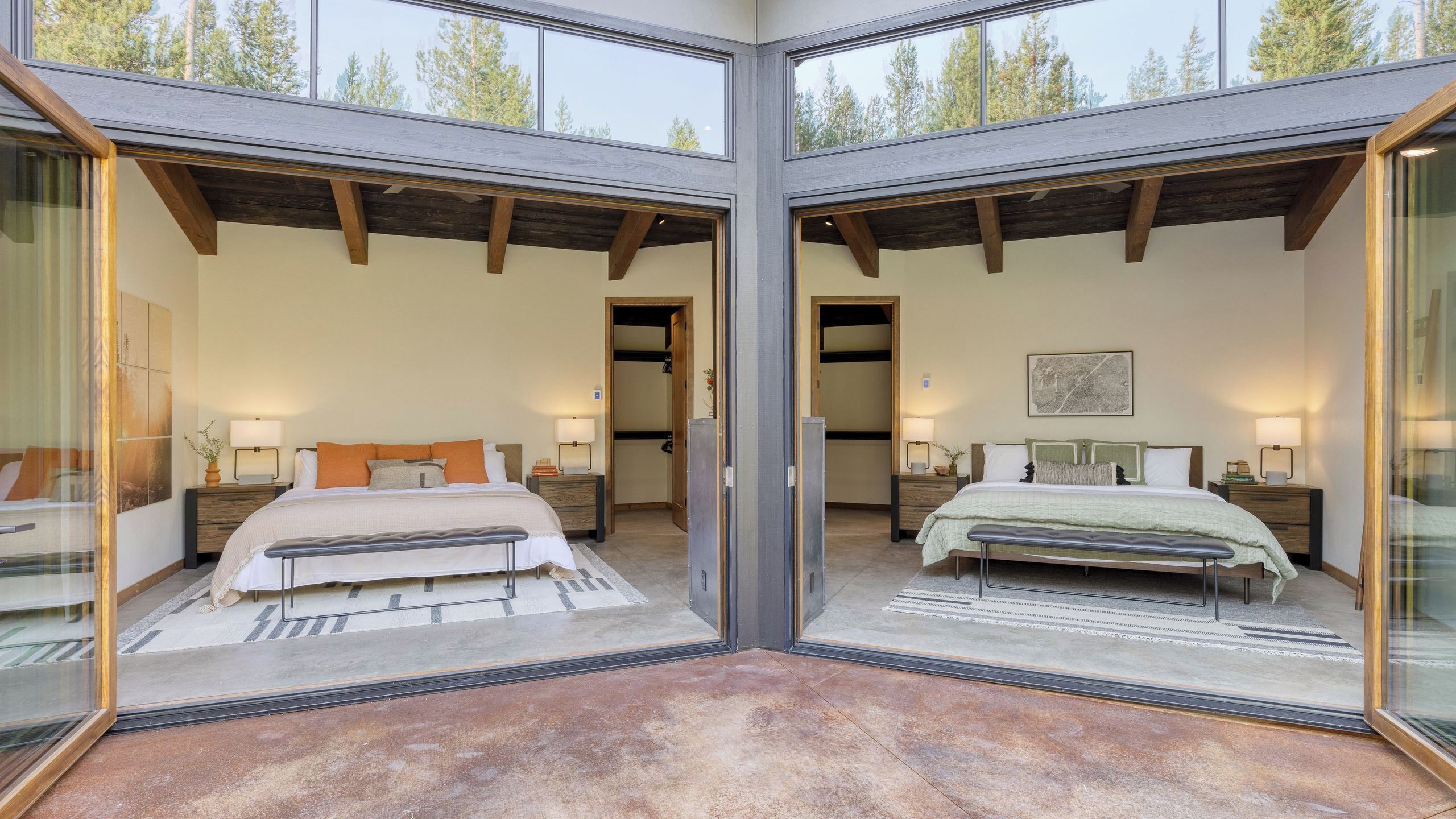 Habitación con espejo, dos camas, vigas de madera y un ventanal amplio.