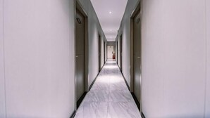 A long, narrow hallway with doors on both sides, leading to rooms. - Jingzhou Orange Flower Boutique Hotel (Shashi Tiandi Branch) (Jingzhou)