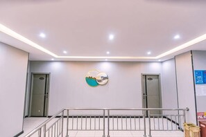 Un interior moderno con una escalera, dos puertas y una obra de arte colgada en la pared.