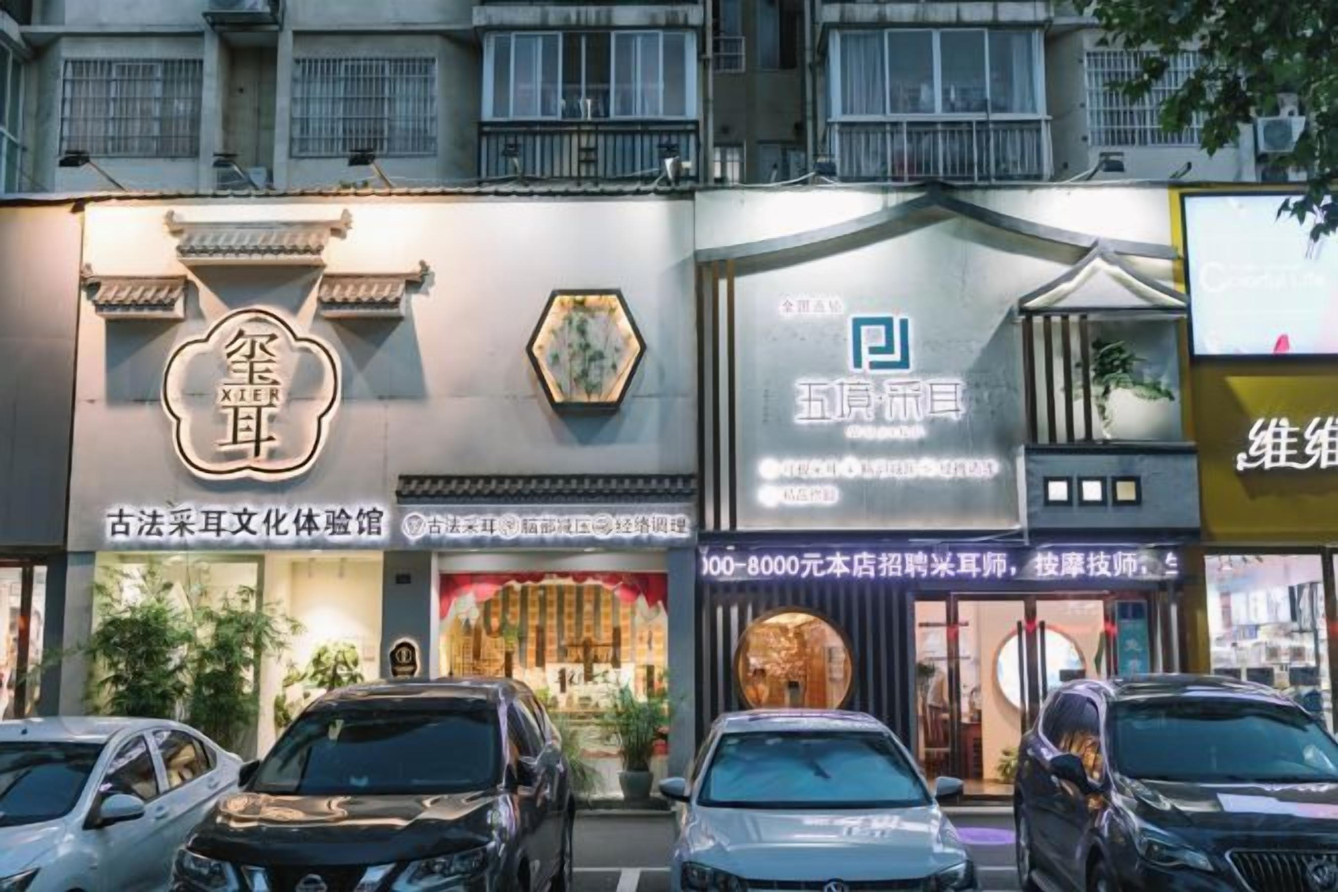Een rij gevels met reclameborden, waaronder een met een traditioneel Chinees karakter en een ander met een blauw-wit bord.